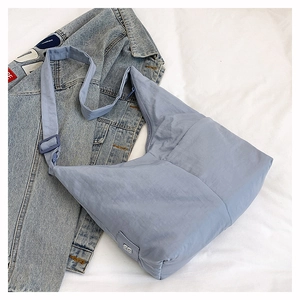 Detail of light blue nylon tote bag showing spacious interior and wide shoulder strap
