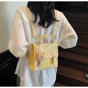 Detail of yellow leather backpack with rhinestone flap and cute bear plush charm