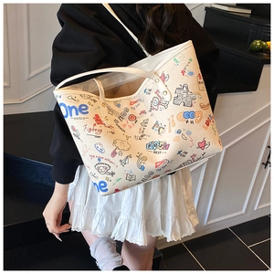 Detailed close-up of large cream tote bag with vibrant artistic graffiti patterns