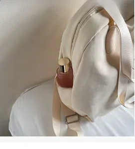 Detail der beigen Rucksack-Seitentasche mit rosa Flasche und verstellbarem Gurt