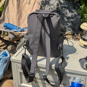 Close-up of waterproof dark gray functional backpack with drawstring side pockets