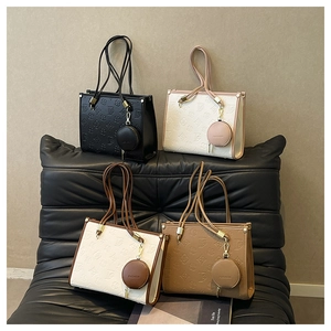 Detail of four chic tote bags with floral embossed pattern and round coin purse charms
