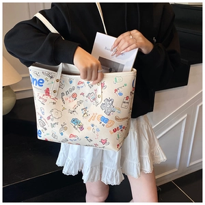 Détail du grand sac cabas blanc avec motifs graffiti colorés et rivets métalliques robustes