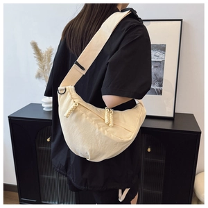 Borsa a tracolla a mezzaluna in tela beige con tracolla larga e dettaglio zip intrecciato