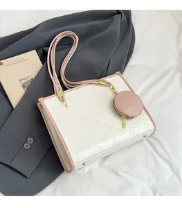 Close-up of white embossed tote bag with pink straps and a fashion mini coin purse
