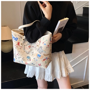 Detail of white tote bag with colorful cartoon graffiti and slender shoulder straps