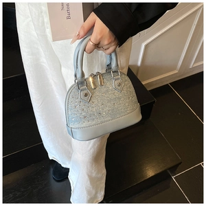 Détail du sac coquille bleu clair avec strass étincelants et finitions dorées chic