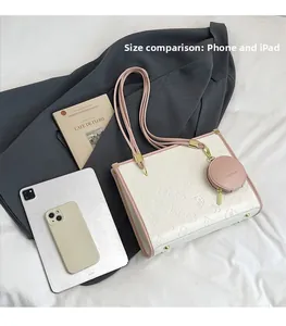 Detail of large beige tote bag with embossed pattern next to iPad and phone