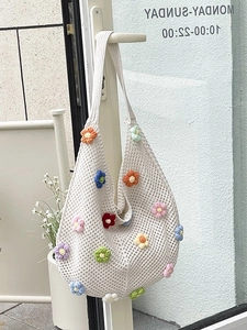 Handmade crochet tote bag in cream white with colorful floral patterns and shoulder strap