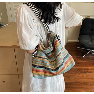 Detail of bohemian striped woven hobo bag with a patterned shoulder strap for beach holidays