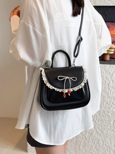 Borsa nera in pelle PU con pizzo bianco e fiocco indossata da una modella