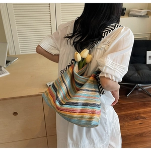 Close-up of vibrant colorful striped woven tote bag with tulip props for summer vacation