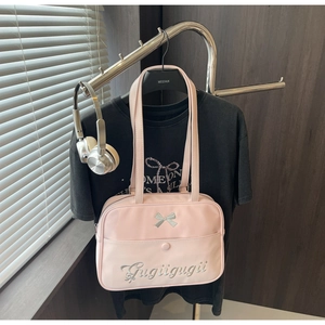 Detailed view of pink JK style shoulder bag with bow embroidery and silver headphones
