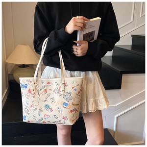 Détail du sac cabas crème avec imprimés graffiti colorés et anses d'épaule robustes