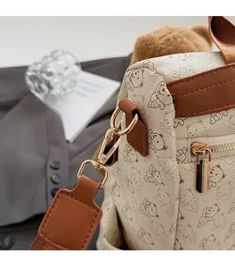 Close-up of cute bear pattern backpack featuring gold hardware and leather trim details