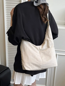Minimalist cream nylon hobo tote bag for women shown as a stylish crossbody daily look
