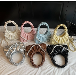 Detail view of colorful pleated cloud bags with glossy leather and pearl chain straps