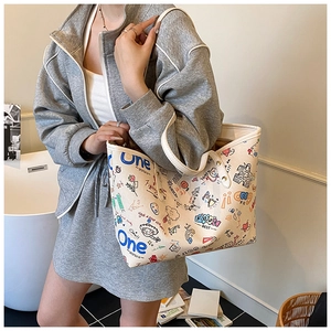 Close-up of lifestyle graffiti tote bag with artistic prints on a beige canvas surface