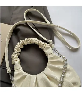 Detail of cream pleated cloud bag showing glossy leather texture and multiple straps