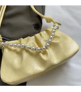 Dettaglio della borsa nuvola giallo crema con ecopelle a pieghe e manico di perle