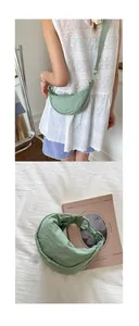 Détail du sac croissant en nylon vert clair avec large bandoulière et texture plissée