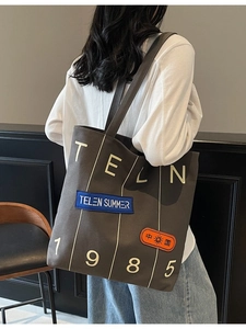 Large dark grey canvas tote bag with bold 1985 lettering and stylish shoulder strap