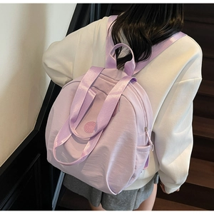 Nahaufnahme eines hellvioletten wasserdichten Nylon-Rucksacks mit Logo und Seitentasche