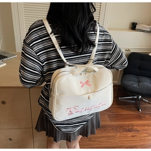 Detail of cream PU leather bag with pink bow embroidery and Gugigugii lettering