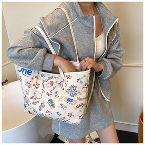 Close-up of stylish white tote bag featuring colorful graffiti prints and slogans