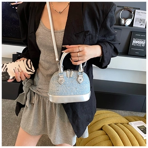 Detailed shot of a silver rhinestone-studded mini shell bag featuring a sleek top handle