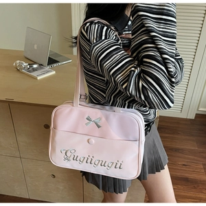 Macro detail of pink synthetic leather shoulder bag with silver bow and Gugiigugii embroidery