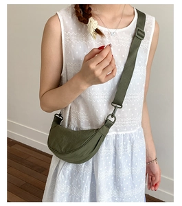 Détail d'un sac demi-lune en nylon vert olive avec une large bandoulière réglable pratique