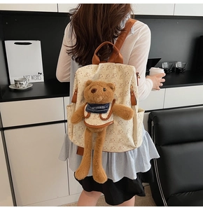 Detail of off-white backpack with cute bear print and a plush 3D bear charm
