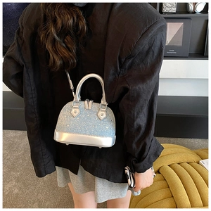 Detail of mini shell bag showing sequin texture and silver mirror leather trim
