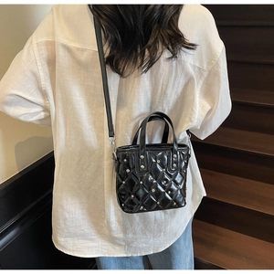 Quilted black bucket bag detail with silver rhinestone accents and leather texture