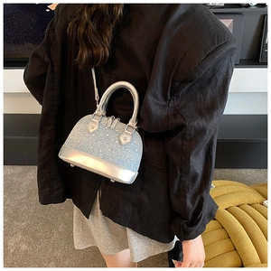 Détails du mini sac coquillage en denim bleu clair orné de strass brillants et miroir
