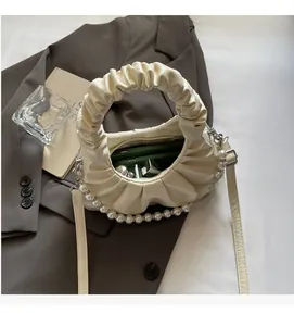 Detail of cream pleated cloud bag with pearl chain strap and leather interior storage