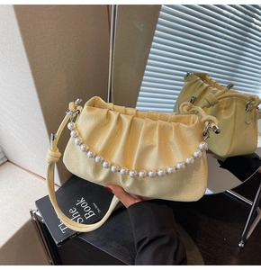 Dettaglio borsa a nuvola plissettata giallo chiaro con manico in perle e anelli strass