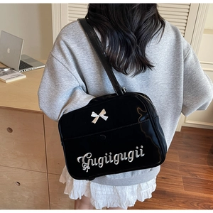 Detail of black patent leather shoulder bag with white bow and Gugiigugii embroidery