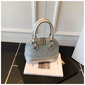 Détails du sac coquille en jean bleu orné de strass brillants et de finitions argentées