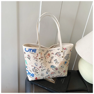 Gros plan du sac cabas crème avec graffiti coloré et rivets métalliques résistants