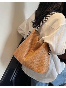 Large bohemian straw tote bag with black and white striped straps for beach vacations