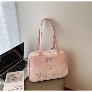 Pink JK style crossbody bag with bow detail and Gugiigugii embroidery on office desk