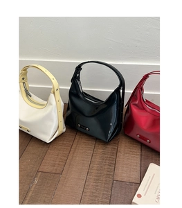 Vue détaillée de sacs hobo brillants en blanc, noir et rouge avec logo en métal