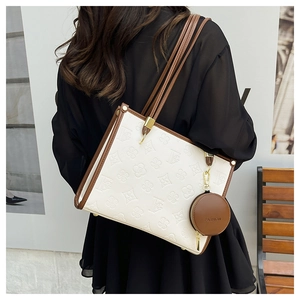 Detail view of white tote bag with embossed floral texture and brown round coin purse