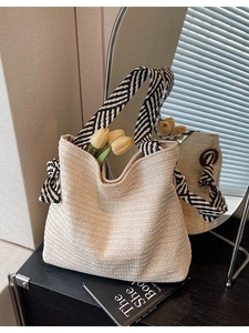 Cream handmade woven straw tote bag with black and white herringbone patterned straps