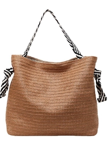 Large bohemian straw woven tote bag with black and white striped handles for beach vacations