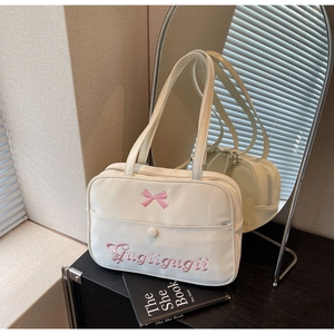 Detail of white nylon shoulder bag with pink bow embroidery and stylish text on front