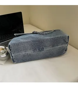 Detailed view of durable denim shoulder bag with silver chain strap and neat stitching