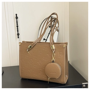 Detail view of embossed coffee PU tote bag with a round fashion coin purse charm